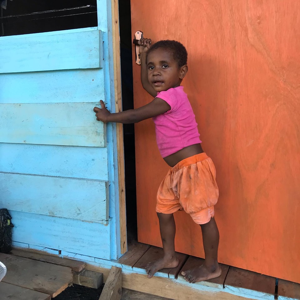 A child outside one of the temporary houses built by government at one of the camps. This is camp is one of the only places where government has built actual buildings but there is only enough for 18 families.